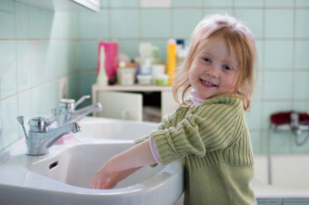 Little girl washing her hands.