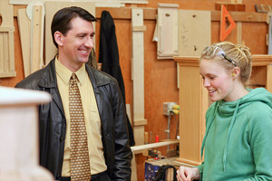 Eric Sehn talking to one of the woodworking student.