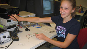 Girl working on electronics gear during Camosun's Taste of Electronics.