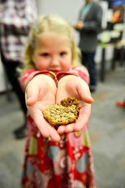Young girl holding a bowl of edible insects at Pestival